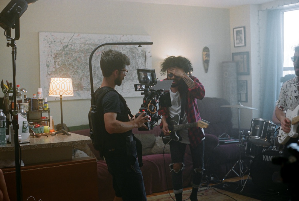 Nicolas J. Capra operating handheld camera on a music video set